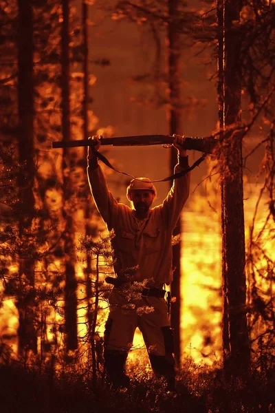 hunting man / hunter with a gun hunting in the autumn forest, yellow trees landscape in the taiga