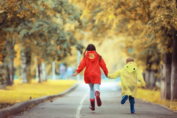 孩子们在黄秋公园里跑雨 好玩地走秋季时景天气湿润 — 图库照片