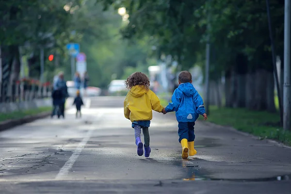 孩子们跑在雨衣 夏季公园 散步兄弟姐妹 儿童男孩和女孩 — 图库照片