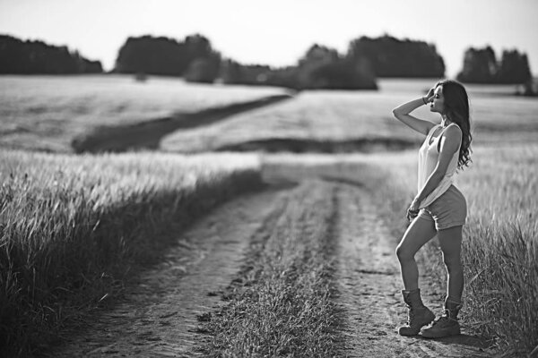 Sexy girl in a t-shirt in a field / summer look, a beautiful young adult sexy model