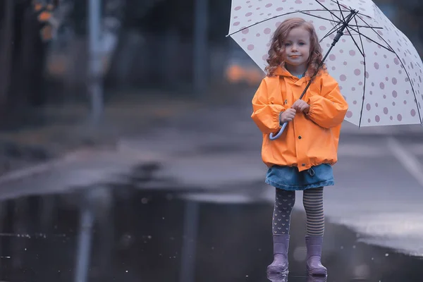 ゴムブーツの女の子水たまり 概念天気 子供のための暖かい服 — ストック写真