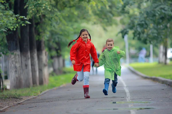 孩子们跑在雨衣 夏季公园 散步兄弟姐妹 儿童男孩和女孩 — 图库照片