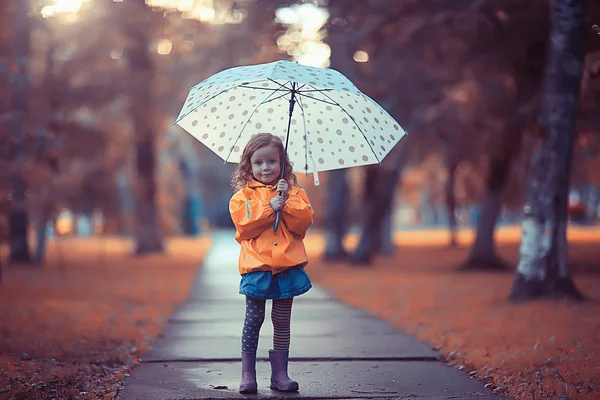 レインコートを着た子供は雨の中で外で遊ぶ 季節の写真 秋の天気 子供のための暖かい服 — ストック写真