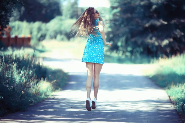 俏皮的成年年轻女孩在夏天漩涡跳跃 欢快美丽的模型在公园 夏天看在短裙 — 图库照片