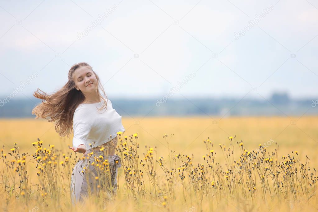 blonde with long hair in autumn field / concept of happiness health young adult model in summer landscape