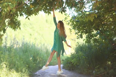 yaz girdaplar atlayan / parkta neşeli güzel model, kısa bir etek yaz bakmak, bacaklar