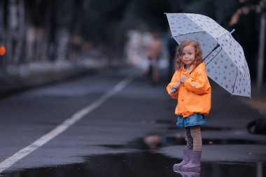 lastik botlar su birikintisi / sonbahar, konsept hava, yağmur, çocuklar için sıcak giysiler kız