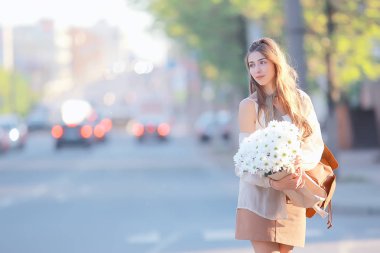 çiçek bir demet kız sokak arabaları / kentsel görünümü, çiçek tutan bir model genç kız ile manzara yürüyor