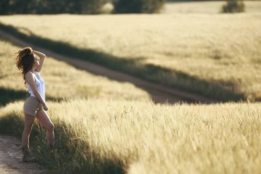 buğday tarlası yaz manzara, mutlu genç model / özgürlük ve rahatlama kavramı yaz ve sonbaharda
