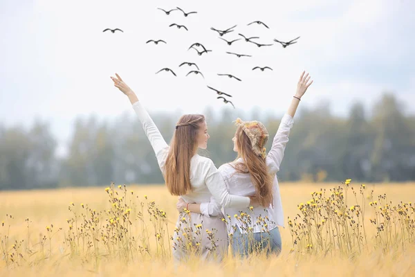 秋の野原の幸せで二人のガールフレンド 野原で抱き合う2人の若い女性 幸福の友情 — ストック写真