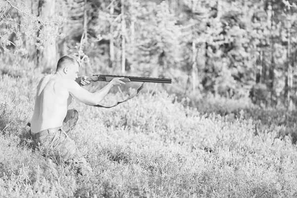 hunting man / hunter with a gun hunting in the autumn forest, yellow trees landscape in the taiga