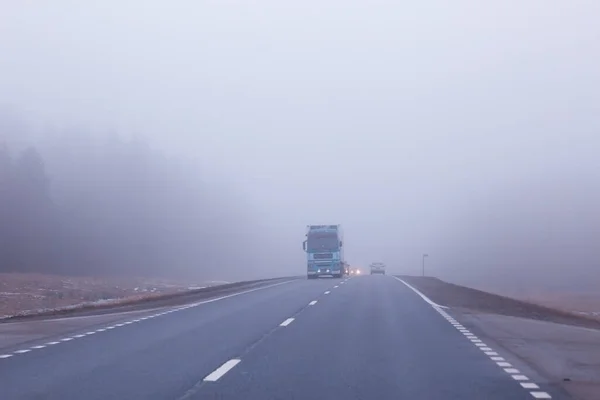 霧の中の道路ハロウィーンの10月の風景の霧高速道路 — ストック写真