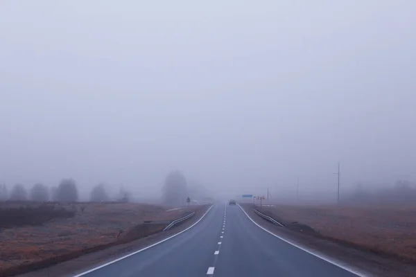 霧の中の道路ハロウィーンの10月の風景の霧高速道路 — ストック写真