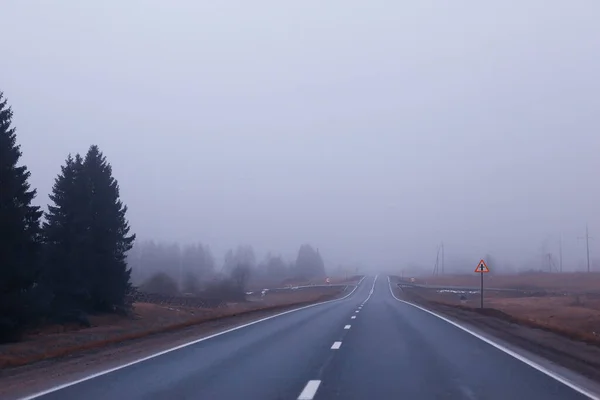 霧の中の道路ハロウィーンの10月の風景の霧高速道路 — ストック写真