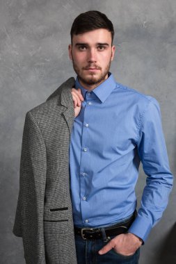 Yakışıklı genç adam gri arka plan üzerinde iç ayakta