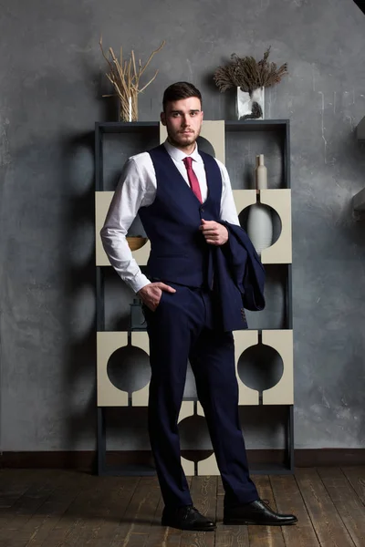 Elegancki człowiek w trzyczęściowy kombinezon stoi w pracowni wnętrz — Zdjęcie stockowe