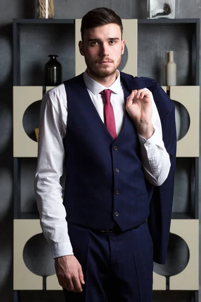 Elegancki człowiek w trzyczęściowy kombinezon stoi w pracowni wnętrz — Zdjęcie stockowe