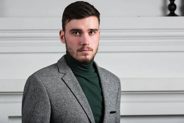 Guapo joven con estilo de pie en el interior sobre fondo blanco —  Fotos de Stock