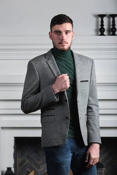 Handsome stylish young man standing in interior on white background — Stock Photo, Image