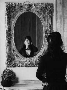 İç stüdyoda siyah seksi elbise ayakta genç güzel kadın model siyah ve beyaz portre.