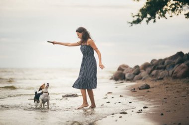 Mutlu kadın köpeğini Sahilde yürürken sarılma 20s görüntüsünü