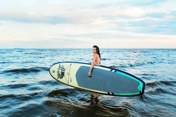 Hermosa chica de surf en forma en la tabla de surf en el océano. Mujer paseo buena onda . — Foto de Stock