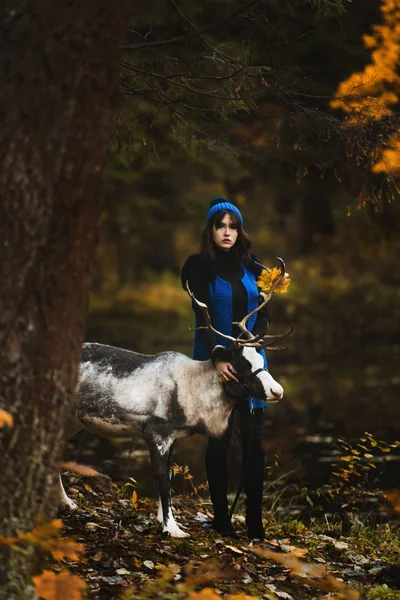 Une belle fille modèle marche avec des cerfs dans le parc — Photo