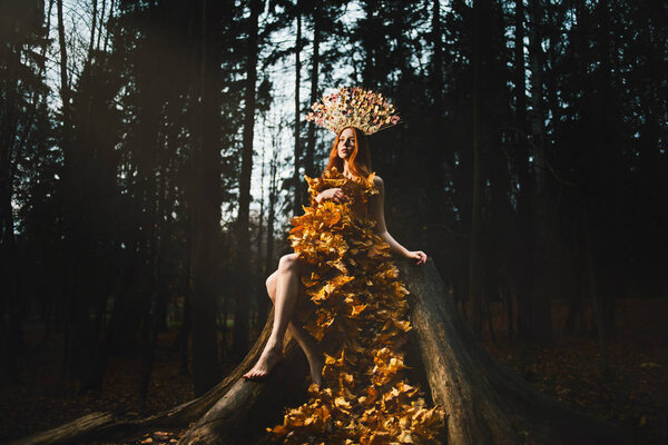Portrait of beautiful red haired Woman in kokoshniks, Fall Leaves Dress, Beauty Girl in the autumn park