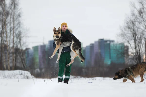 Homme avec un berger allemand dans le parc en hiver — Photo