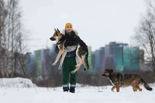 Человек с немецкой овчаркой в парке зимой — стоковое фото