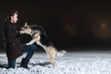Kışın gece yarısı melez bir köpeği olan bir adama yan bakış.