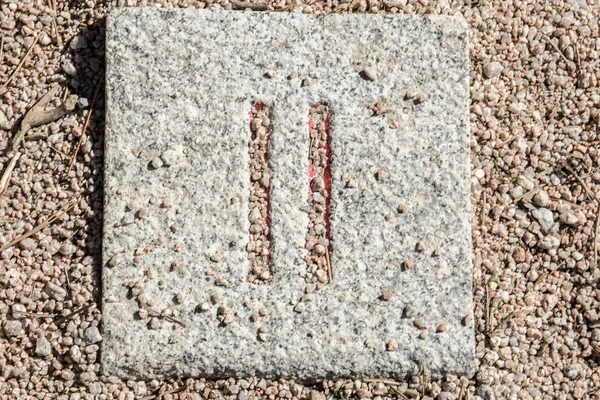 Roman numerals engraved on square granite stones