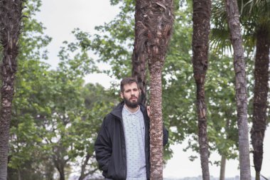 ceket ve palmiye ağaçları ile sakallı genç adam portresi