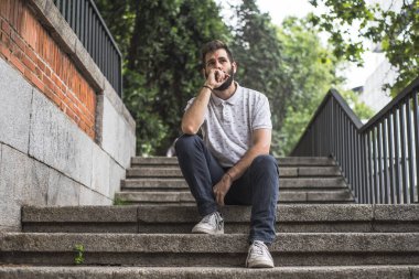 merdivenlerin üzerinde duruldu sakallı genç adam