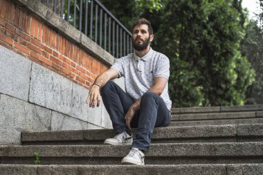 merdivenlerin üzerinde duruldu sakallı genç adam