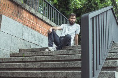 merdivenlerin üzerinde duruldu sakallı genç adam