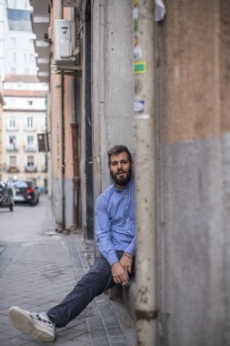 bir sakallı bir kapı aralığında sokakta oturan