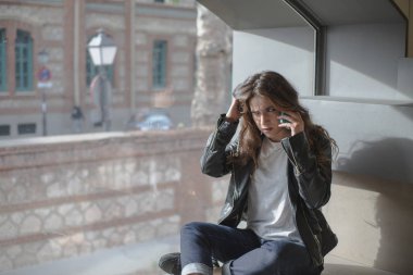 pencerenin önünde oturan telefonda konuşan kız