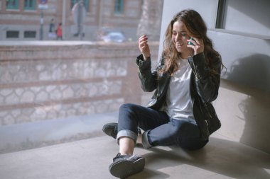 pencerenin önünde oturan telefonda konuşan kız