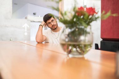 bir kavanoz kaplı bir barda oturan adam