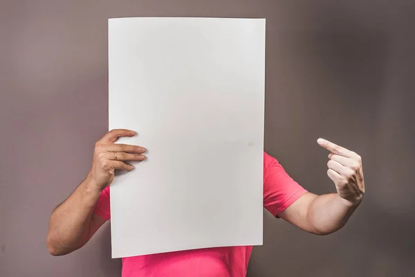 Genç adam elleriyle boş bir poster holding