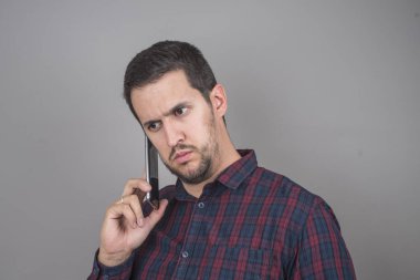 Kareli gömlek ile bir akıllı telefon kullanan adam portresi