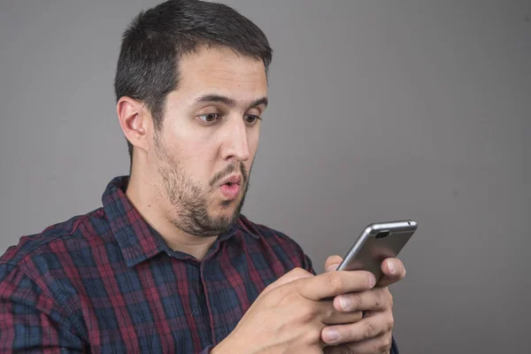 Portrait of surprised man talking on smartphone