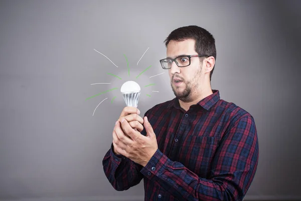 Young man with an idea lights a light bulb