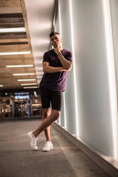 Tall casual young man in a wall of lights