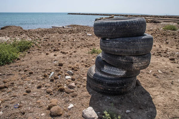 tires stacked and abandoned on the beach