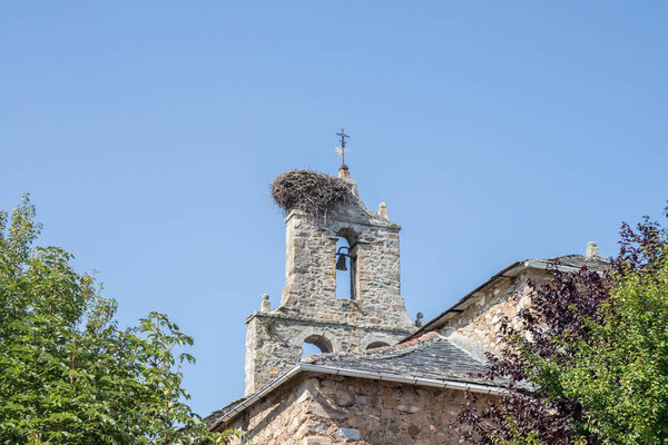village church bell tower with a nest of storks