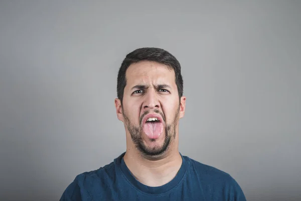 Junger Mann Mit Ekelhaftem Gesicht Das Die Zunge Herausstreckt — Stockfoto