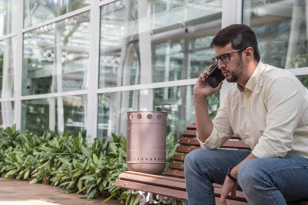 Man sitting on a bench talking on the phone