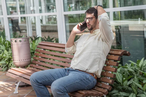 Man sitting on a bench talking on the phone